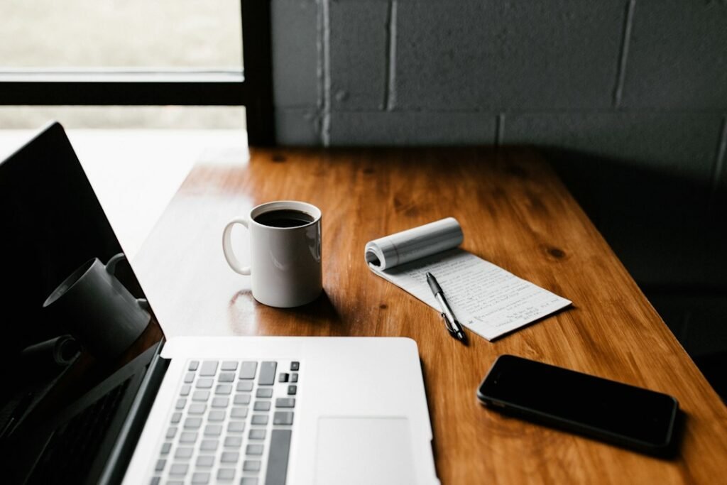 Laptop and notebook representing the best note-taking apps
