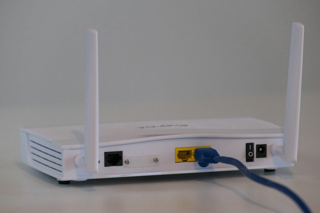 Wireless internet router with an Ethernet cable connected, representing router troubleshooting and reset instructions